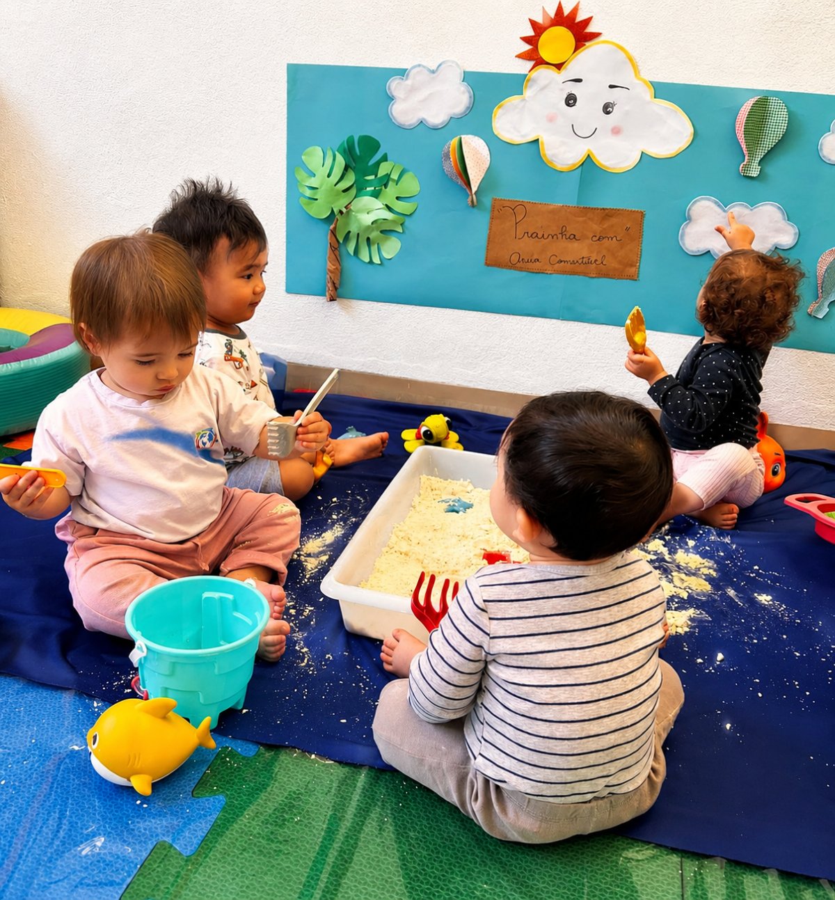 Bebês explorando areia comestível no ateliê sensorial