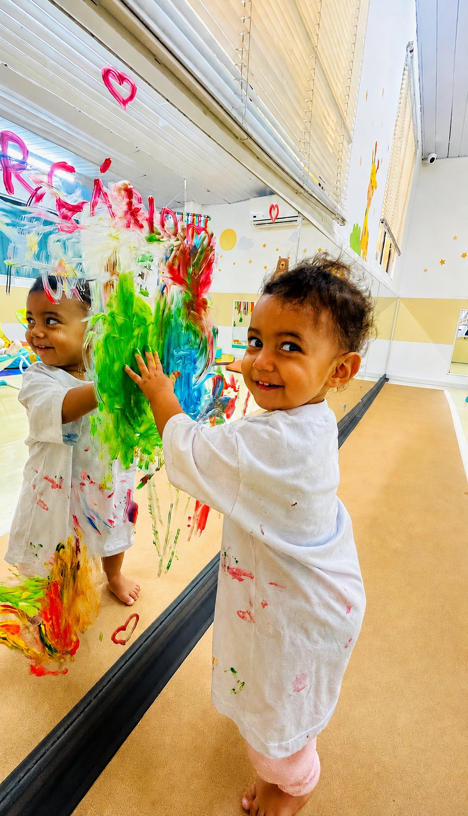Bebê pintando no espelho na atividade dirigida