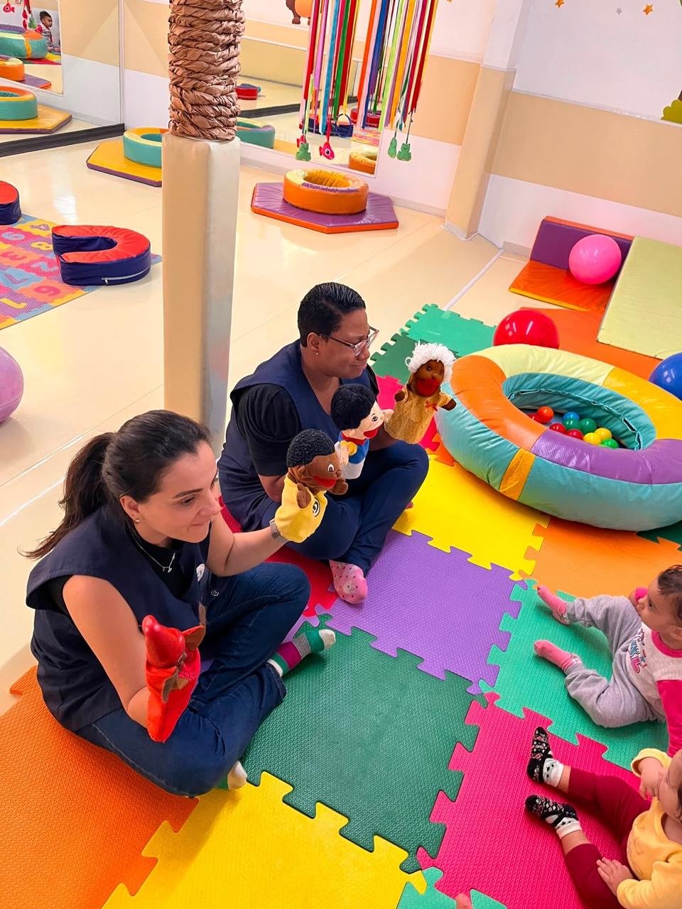Professoras contando história com fantoches para os bebês