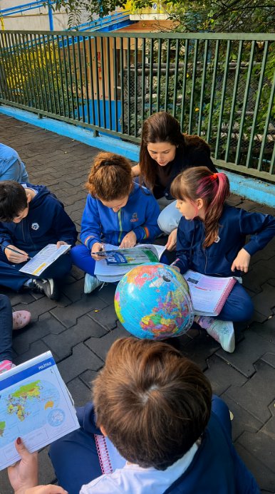 Alunos estudando geografia com globo terrestre ao ar livre
