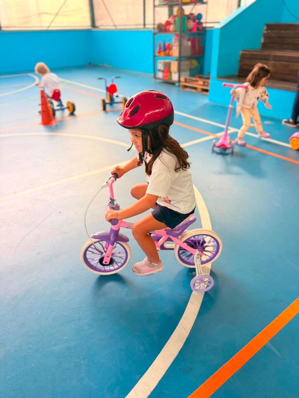 Menina andando de bicicleta na quadra com capacete