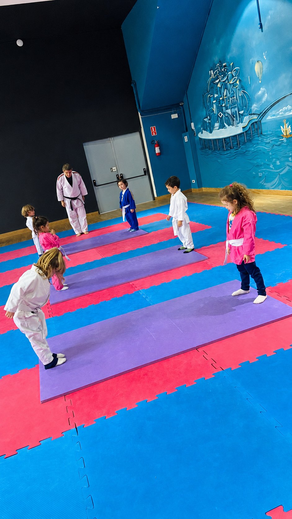 Crianças de kimono em aula de judô no tatame