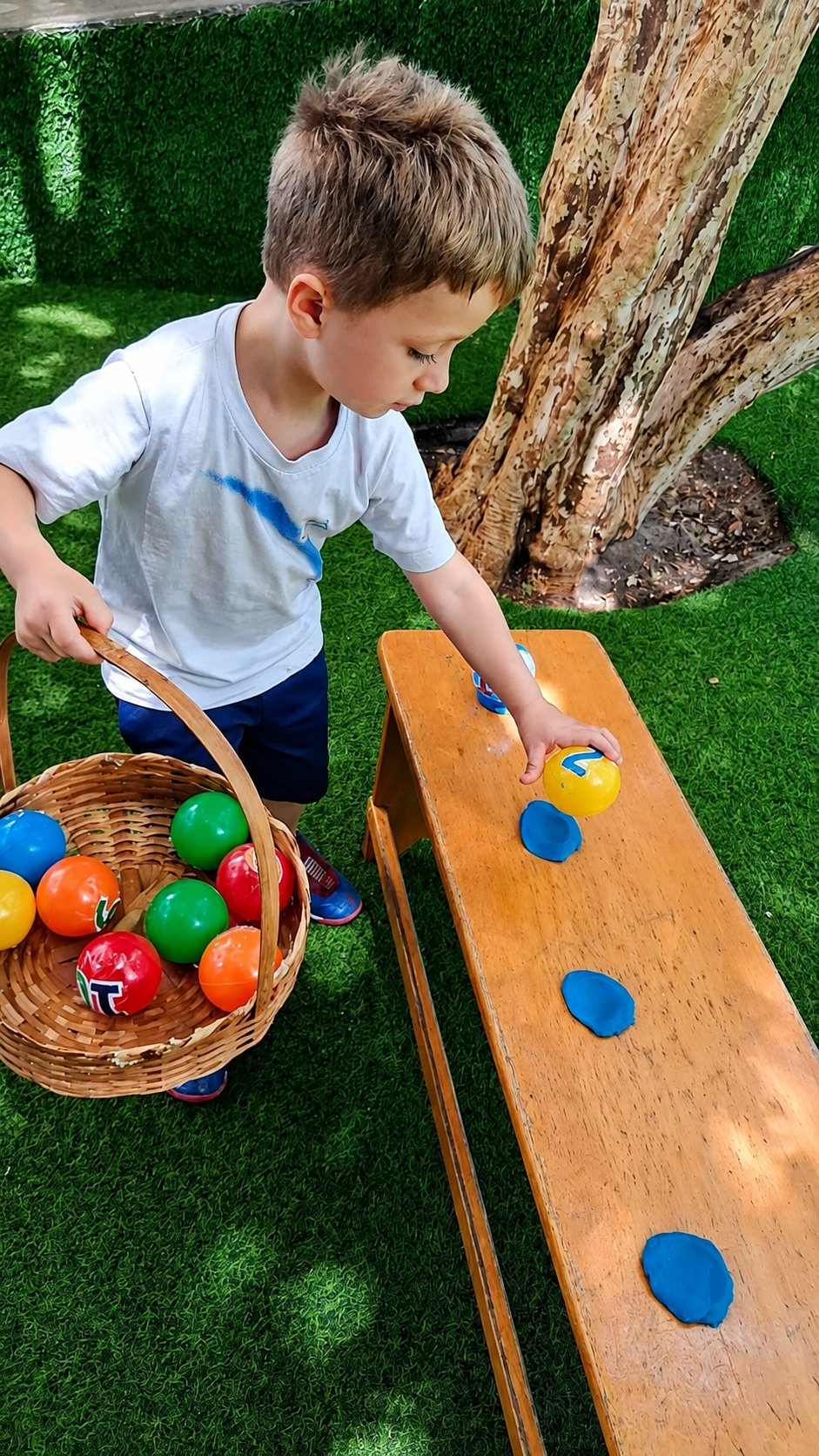 Menino brincando com bolas numeradas na atividade de matemática