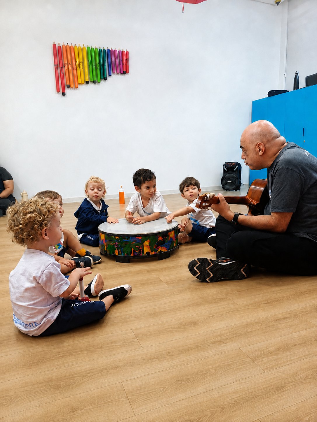 Professor com violão em roda de musicalização com as crianças